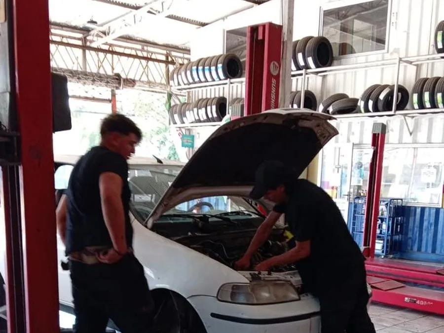 Dos mecánicos revisando el motor de un auto
